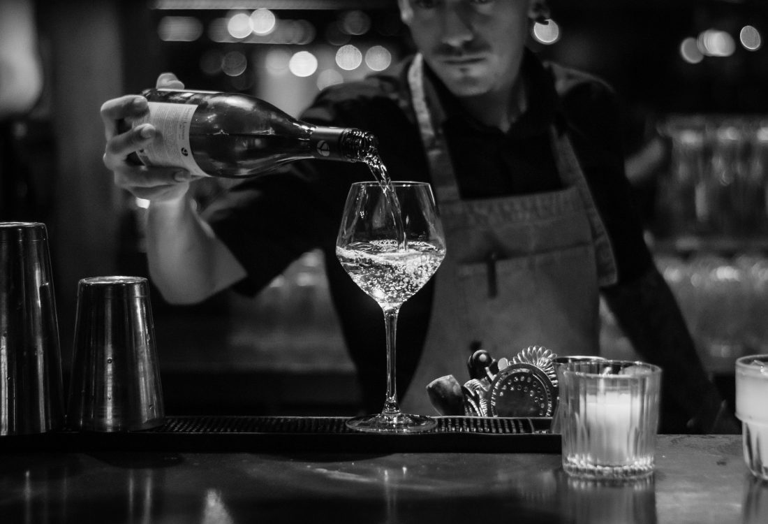 A black and white shot of a wine being poured